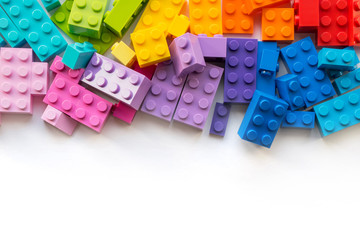 A lot of Colorful Plastick constructor blocks on white background. Popular toys. Copyspace