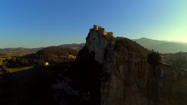 Beautiful aerial view of one of the most beautiful castles in Emilia Romagna, during a day with a clear blue sky and the bright sun, the fortress of San Leo