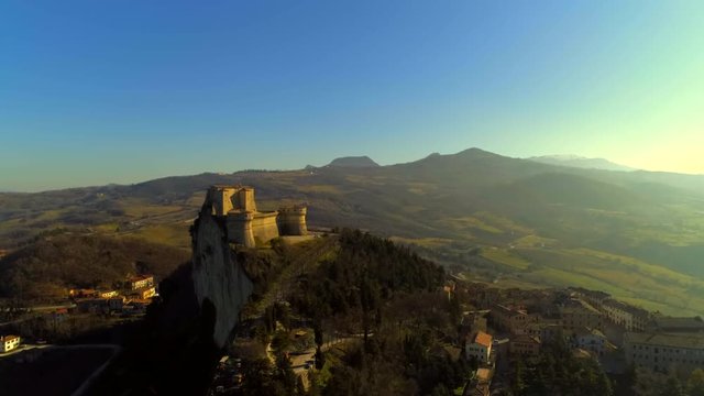 Beautiful aerial view of one of the most beautiful castles in Emilia Romagna, during a day with a clear blue sky and the bright sun, the fortress of San Leo