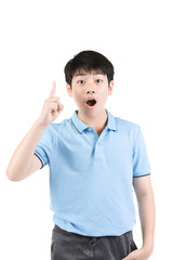 Young Asian boy thinking and pointing  upwards while smiling .