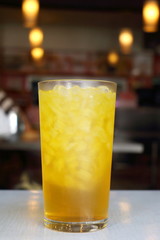 Close up isolated Chrysanthemum ice tea glass on table in chinese restaurant , yellow herbal water for drink will felling fresh in summer.