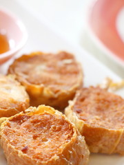 Closeup deep fried crab meat roll cake (Hoi Jo) in white plate with sweet sauce in dim sum set, crab meat in tofu wrap, Chinese restaurant food style