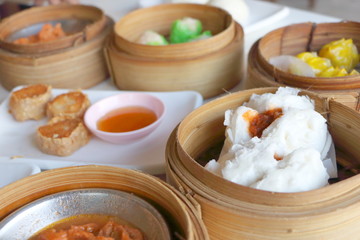 Closeup deep Chinese steamed red pork bun break can see pork inside in bamboo basket in dim sum set, Chinese restaurant food style