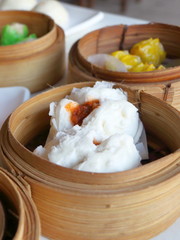 Close up Chinese steamed red pork bun is break can see pork inside in bamboo basket on table look delicious