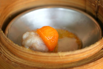 Close up egg yolk on streamd pork in bamboo basket in Chinese dim sum set