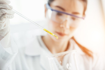 Young female researcher are doing investigations with test tubes. cientists are working in laboratory