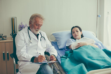 Obraz premium The doctor is examining the symptoms of the person. The doctor touched the forehesd of the patient