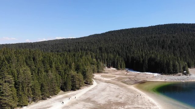 4k drone shot over a beautiful mountain forest lake - aerial cinematic view.