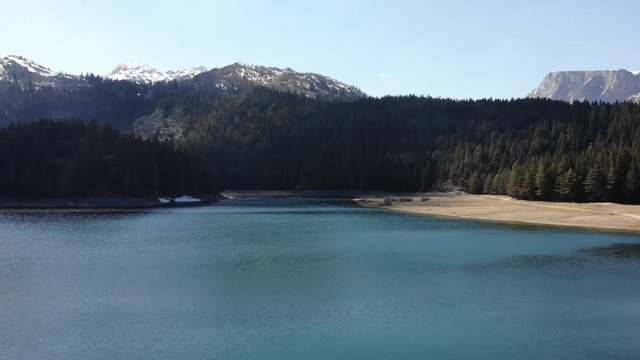 Aerial View 4k - Drone shot over a beautiful mountain forest lake