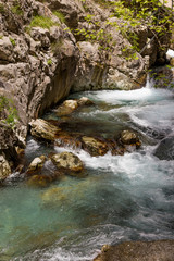Naklejka na ściany i meble Powerful water stream in the mountain canyon