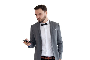 Handsome businessman in suit. Young smiling business man in blue shirt reading sms, using smartphone