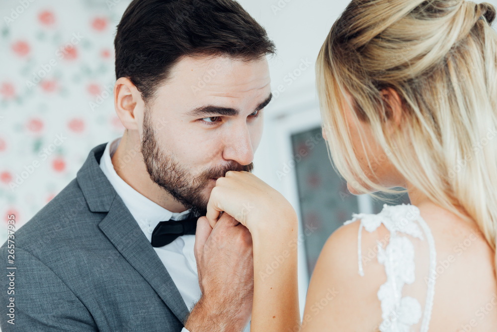 Wall mural bearded man kisses woman's hand. man kissing a woman's hand over white background.