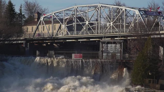 slow motion shot of flood water flowing over a dam