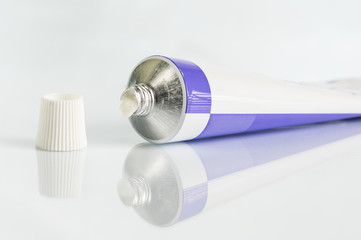 ointment for external use a little squeezed out of a tube on a white background, near the cover