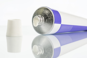 ointment for external use a little squeezed out of a tube on a white background, near the cover