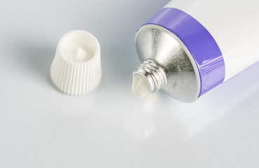 ointment for external use a little squeezed out of a tube on a white background, near the cover