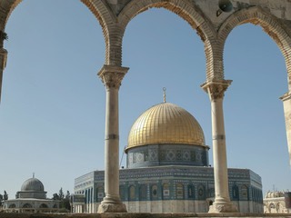 dome of the rock mosque framed by arches in jerusalem