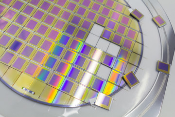 Silicon wafer with microchips fixed in a holder with a steel frame after the dicing process and separate microchips.