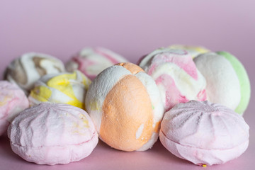 colorful marshmallows - zephyrs on pink background. Colorful meringues on pink. Many sweet zephyrs. Trendy top view dessert image.