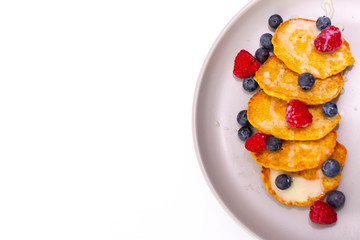 Fritters with berries on a plate on a white background
