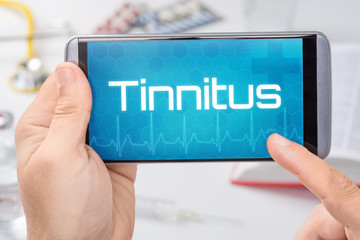 Smartphone mit dem Text Tinnitus auf dem Display