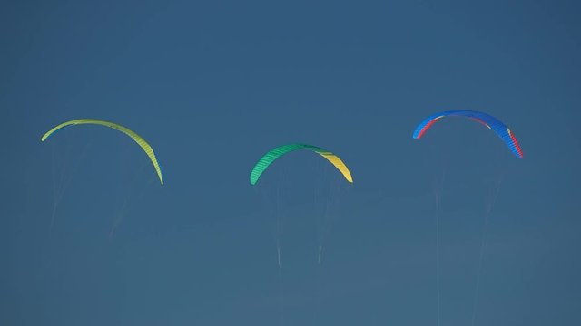 Paragliding In Winter Above Frozen Lake.  Extreme Sport,  Healthy Lifestyle And Freedom Concept. People paragliders training, sunny and windy weather, blue sky. 
