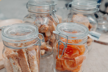 Fototapeta na wymiar Glass jars with cookies and candied fruit on the table. Horizontal orientation. Flat lay. 