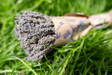 Lavender bouquet in paper packaging lying on the green grass. Horizontal orientation. Copy space. 