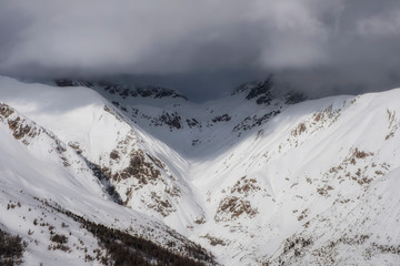 Fototapeta na wymiar The sun, clouds and fog in Alpine Ski Resort And Ski Slopes in Winter, Livigno, Italy