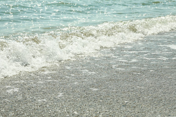 Seashore with small wave, close up. Summer background