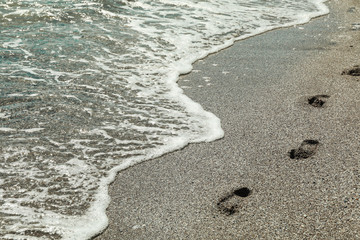 Seashore with footprints, space for text. Summer background