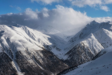 The sun, clouds and fog in Alpine Ski Resort And Ski Slopes in Winter, Livigno, Italy