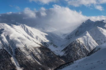 Fototapeta premium The sun, clouds and fog in Alpine Ski Resort And Ski Slopes in Winter, Livigno, Italy