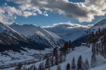 Winter view from the top on Livigno city and lake Livigno. Italy.