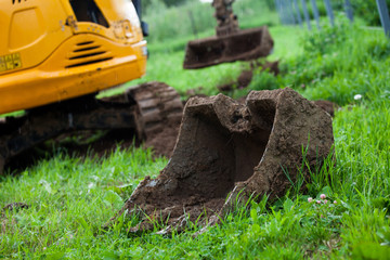The excavator levels the earth on the site