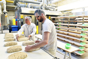 Arbeiter am fliessband in einer Großbäckerei - Herstellung von Brot in einem Werk