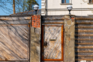 Old crumbling wooden fence and massive door