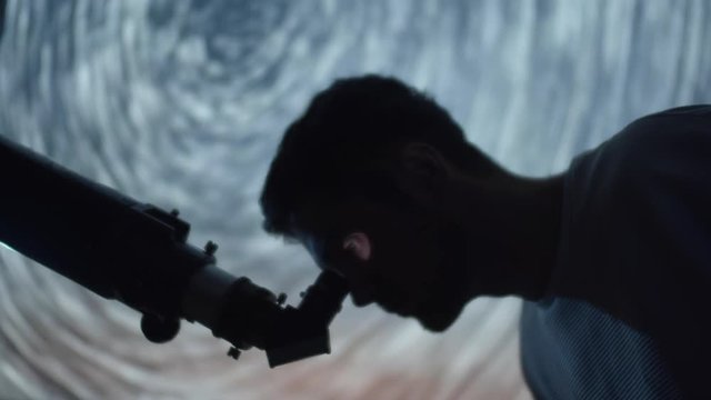 Astronomer Man in moonlight looking at sky using telescope with stars swirling