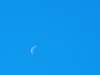 Moon during the day with blue sky
