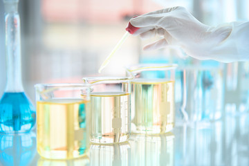 scientist in laboratory with test tubes, Test tubes with liquid in laboratory, Doctor hand holding dropper with dripping or transparent glass pipette, dropper for instillation. scientist working in la