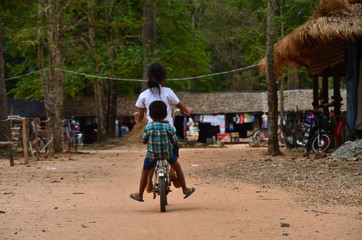 カンボジアのシェムリアップ　世界遺産のアンコールワット遺跡群　遺跡内の住居とお店　自転車に乗るカンボジアの子供