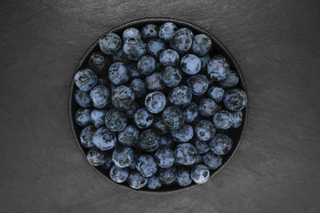 Blueberries on black stone background