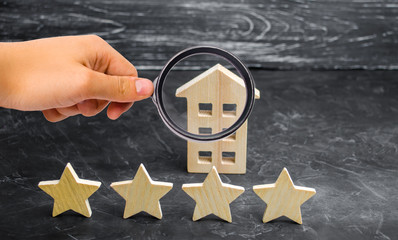 Wooden house and four stars on a gray background. Rating of houses and private property. Buying and...
