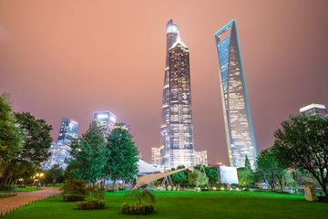 Of tall buildings in the center of the garden green space in the evening.