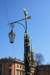 Fototapeta na wymiar lantern with decorations on the background of the building with a spire. 