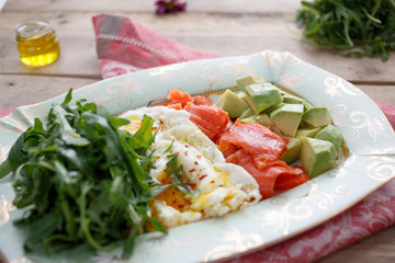 Breakfast with Egg, salmon, avocado and arugula