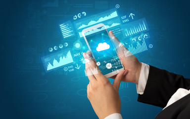 Female hand using smartphone with financial tracking concept illustrated by graphs and symbols