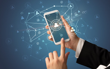 Female hand using smartphone to connect peoples all around the online surface

