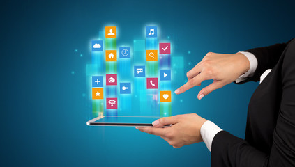 Female elegant hand holding tablet with colourful application icons
