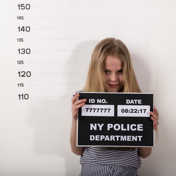 Young beautiful blonde child with a sign, Criminal Mug Shots. difficult children, social tension